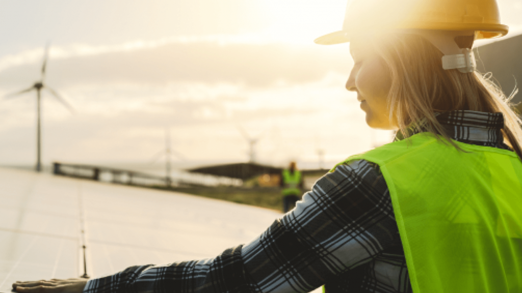 woman in protective gear examining solar panels