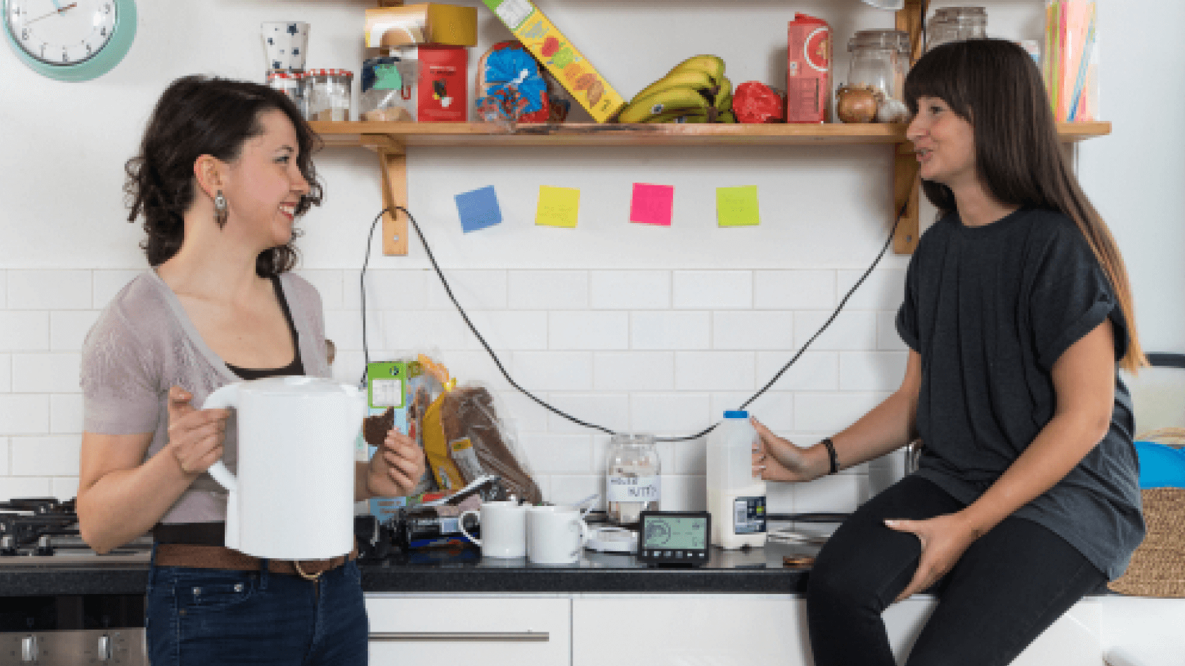 two people having tea with a smart meter on the kitchen side